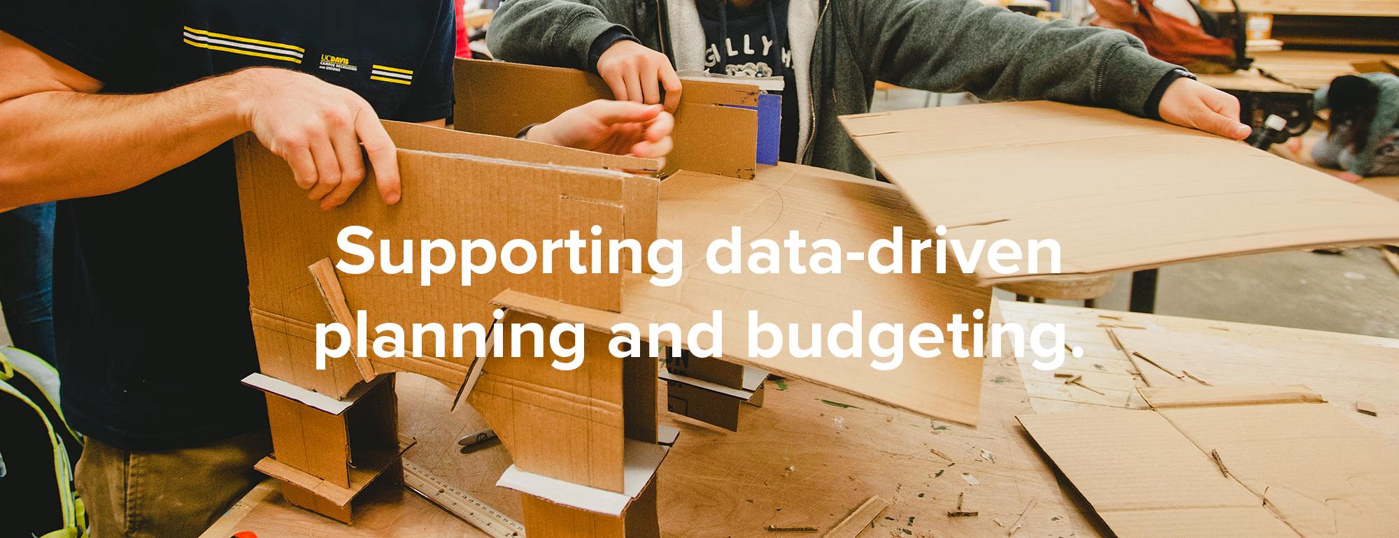 campus data hero banner. two engineering students building a cardboard structure